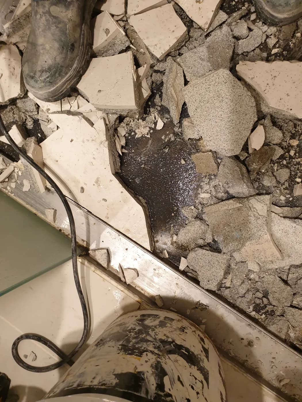Tiling broken out across the bathroom floor during strip-out
