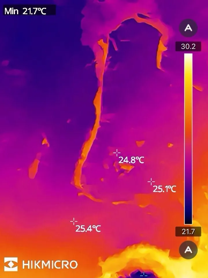 Thermal camera image showing a plume of trapped moisture behind a lining