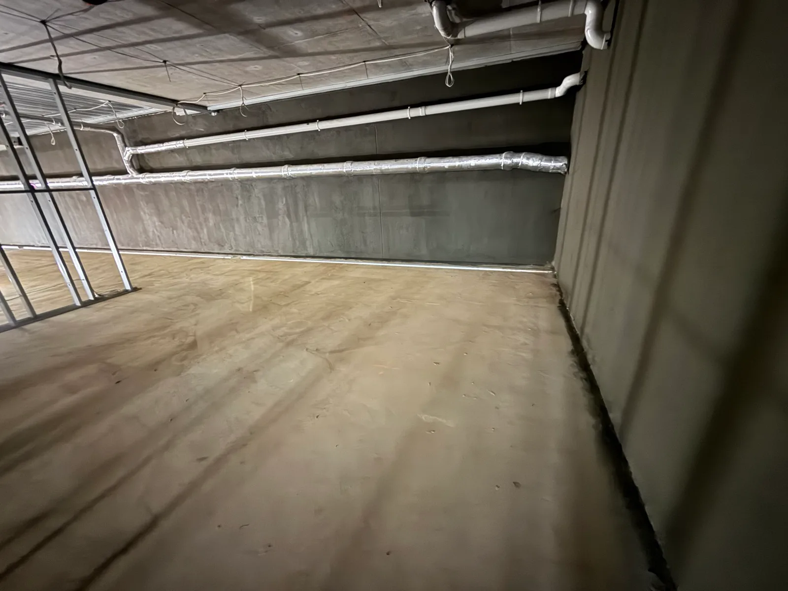 Completed basement rectification with the floor coated and services reinstated overhead
