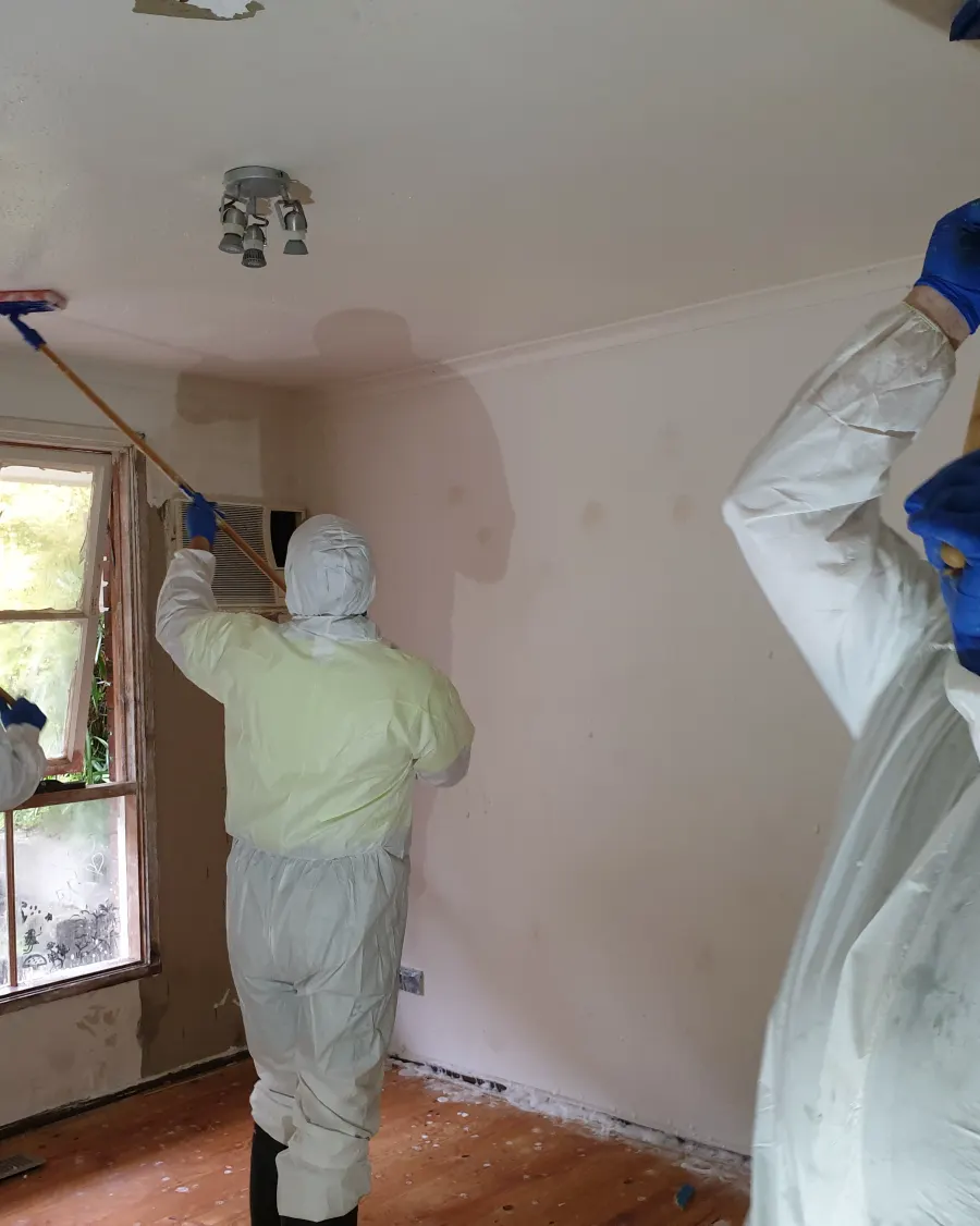 A stripped interior being treated under full protective equipment